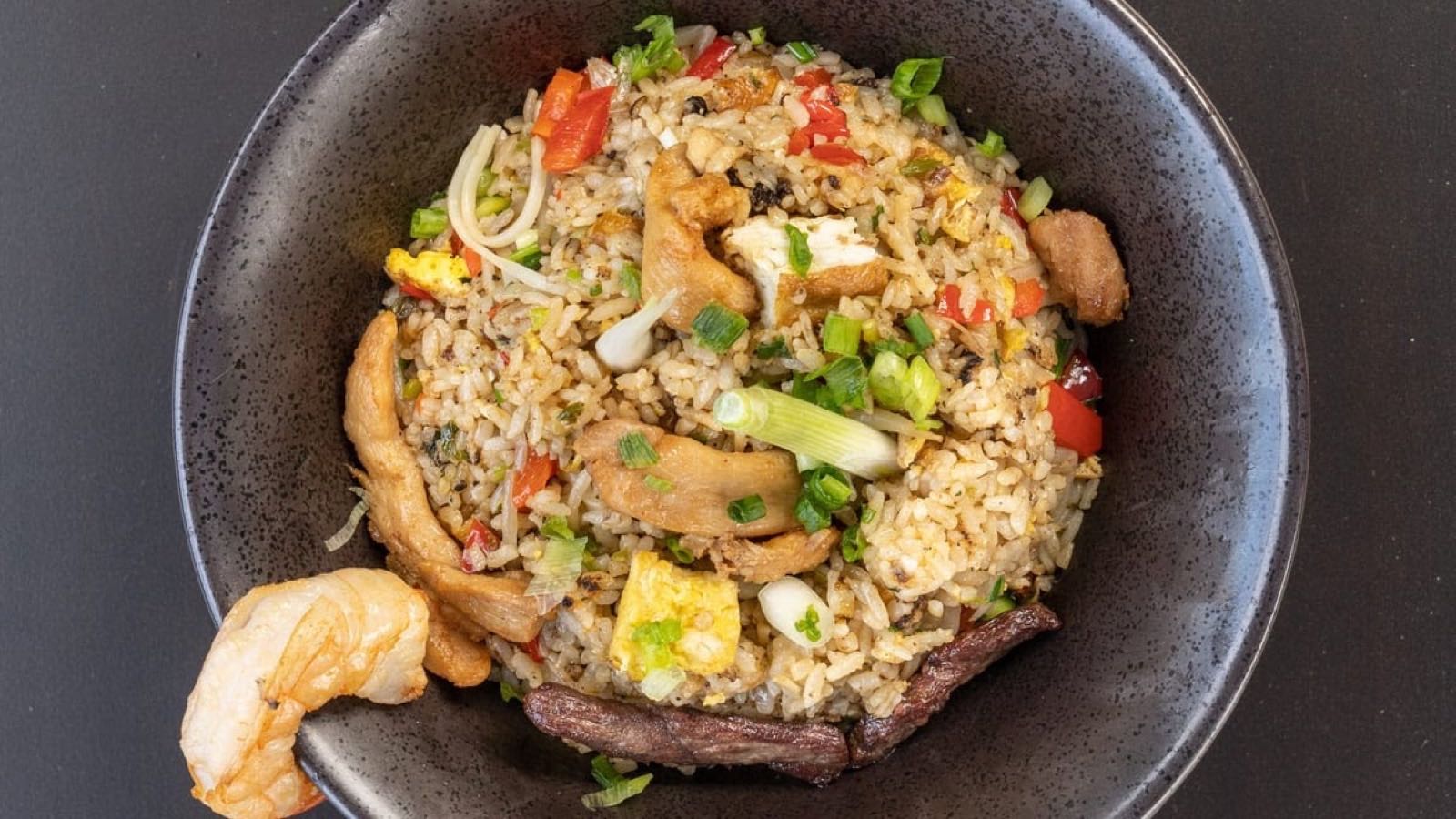 Chaufa fried rice with shrimp, calamari and fish in a stone bowl